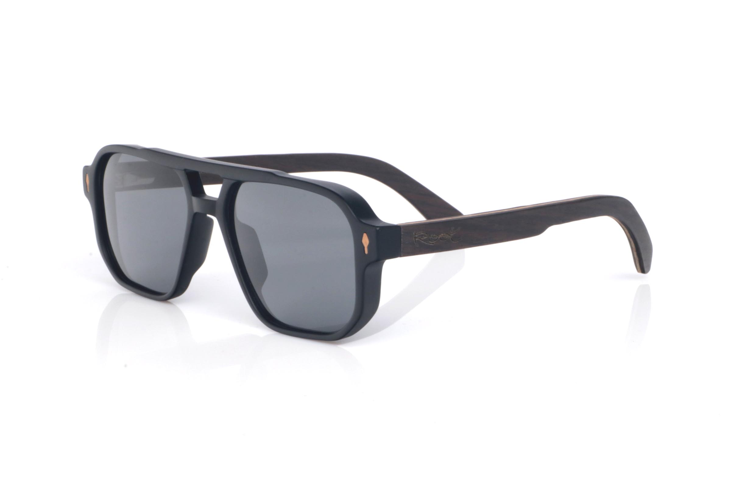 Wood eyewear of Ebony modelo RAYMOND. The wooden sunglasses **RAYMOND** combine a bold, structured front with **ebony temples**, a dark and elegant wood whose subtle grain delivers a refined handcrafted finish. Their navigator-inspired design with a defined bridge creates a strong, balanced presence, while staying comfortable thanks to the lightweight build and the natural curve of the temples. A modern, timeless model with plenty of character, designed for everyday wear, with full UV protection.
Dimensions: 147x48 mm
Caliber: 54
 | Root Sunglasses® 