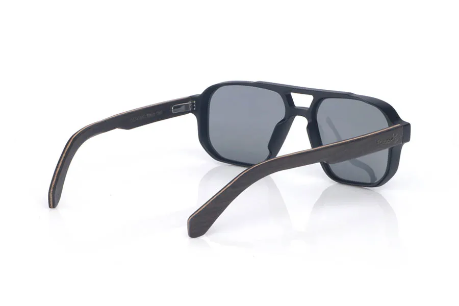 Wood eyewear of Ebony RAYMOND. The wooden sunglasses **RAYMOND** combine a bold, structured front with **ebony temples**, a dark and elegant wood whose subtle grain delivers a refined handcrafted finish. Their navigator-inspired design with a defined bridge creates a strong, balanced presence, while staying comfortable thanks to the lightweight build and the natural curve of the temples. A modern, timeless model with plenty of character, designed for everyday wear, with full UV protection.
Dimensions: 147x48 mm
Caliber: 54
 for Wholesale & Retail | Root Sunglasses® 