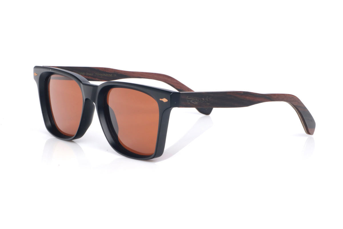 Wood eyewear of Ebony modelo DENVER. The wooden sunglasses DENVER combine a bold, square silhouette with a matte black front, creating a clean and highly versatile look. Their ebony temples add an elegant handcrafted touch, with a subtle grain and a natural finish that contrasts with the solid front. The frame offers comfortable everyday wear thanks to its lightweight build and the curve of the temples, which helps keep a stable fit. A modern, timeless model designed for daily use, with full UV protection.

Dimensions: 145x47 mm
Caliber: 52 | Root Sunglasses® 