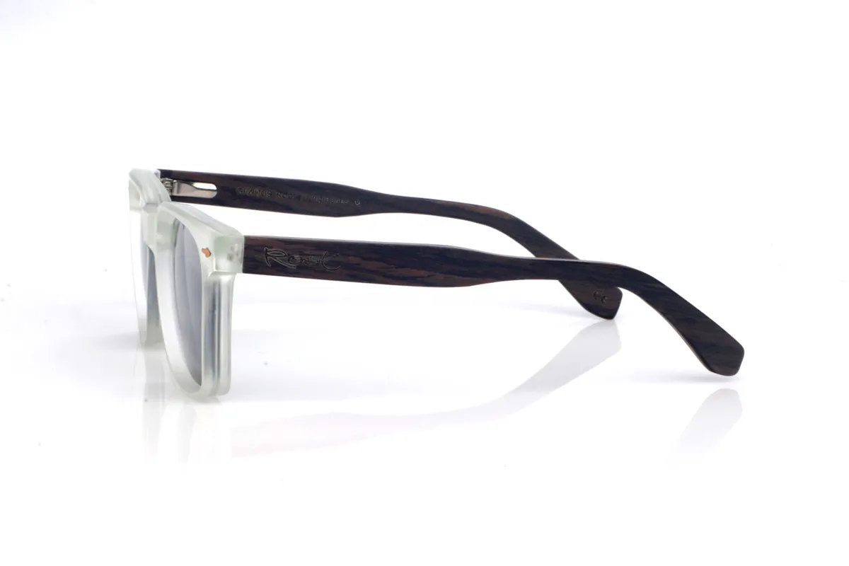 Gafas de Madera Natural de Roble CAMDEM B. Las gafas de sol de madera CAMDEM B combinan una silueta cuadrada y actual con un frontal en tono cristal translúcido, ligero y luminoso, que aporta un look muy limpio y moderno. Sus patillas de roble suman calidez y un carácter artesanal gracias a su veta natural, creando un contraste elegante con el acabado del frontal. La montura está pensada para el uso diario: es cómoda, ligera y con una curvatura de patillas que ayuda a mantener una sujeción estable. Un modelo versátil y atemporal, con protección completa frente a los rayos UV.

Dimensiones: 145x47 mm
Calibre: 52
 Venta al Por Mayor y Detalle | Root Sunglasses® 
