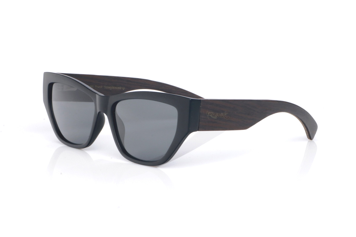 Wood eyewear of Oak modelo SAGE B. The SAGE B OAK wooden sunglasses feature a soft cat-eye design, with a subtle upward line at the corners that flatters the look without feeling exaggerated. The black front adds an elegant touch that’s easy to match with anything, while the contrast with the oak temples brings a warm, natural feel that makes them stand out.

One of their nicest features is the wide temples: beyond reinforcing the character of the model, they visually balance the frame and give the impression of a solid, well-crafted piece. The curve of the temples helps them sit securely, and the overall build stays comfortable for everyday wear, with full UV protection.

Dimensions: 14x45 mm
Lens width (caliber): 55

 | Root Sunglasses® 