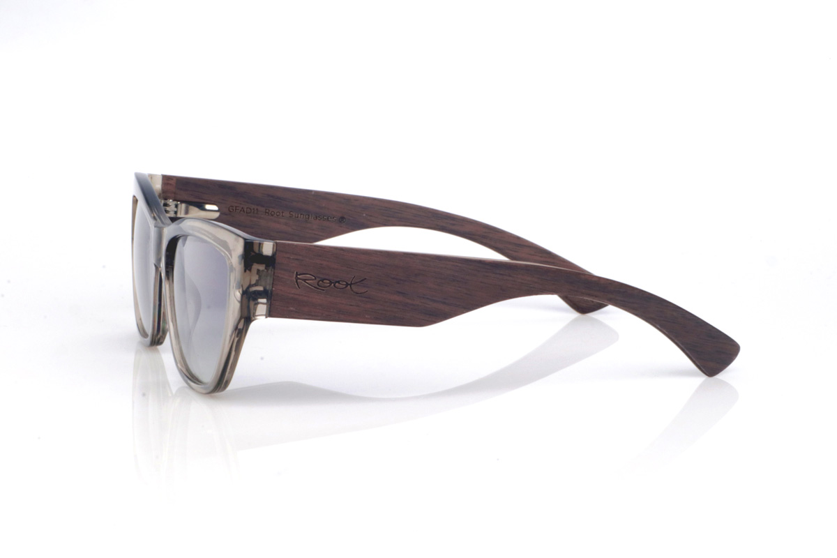 Wood eyewear of Walnut STONE. The STONE WALNUT wooden sunglasses combine a translucent “smoke/stone” front with a slightly cat-eye silhouette that subtly lifts the look. The transparency of the acetate reveals the nuances and joins of the frame, giving it a modern, lightweight feel.
The walnut temples are the standout feature: they visually balance the front, reinforce the sense of a solid, well-made piece, and add the warm contrast of natural wood grain. Their curved shape helps them sit securely, keeping them comfortable for everyday wear, with full UV protection.

Measurements: 145x45
Lens width: 55 for Wholesale & Retail | Root Sunglasses® 