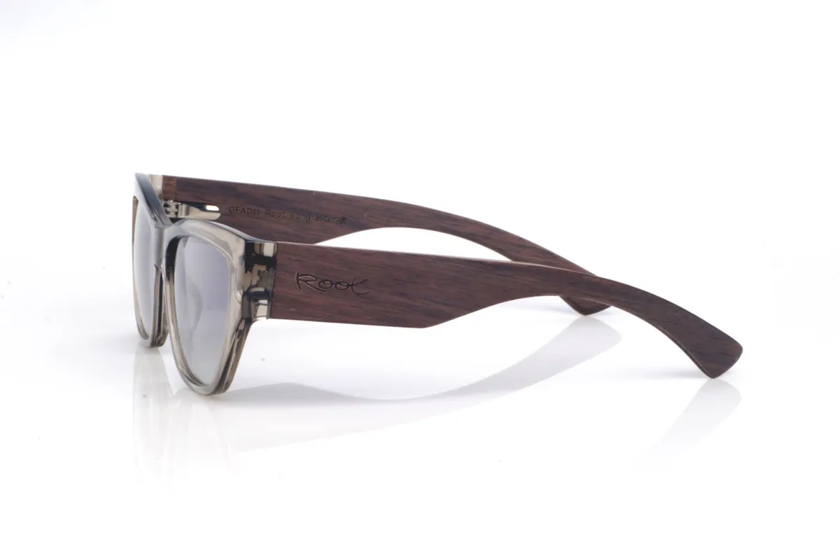 Gafas de Madera Natural de Walnut STONE. Las gafas de sol de madera STONE WALNUT mezclan un frontal translúcido en tono “smoke/stone” con una silueta ligeramente cat-eye que levanta la mirada de forma sutil. La transparencia del acetato deja ver los matices y las uniones de la montura, dándole un aire moderno y ligero.
Las patillas de nogal son protagonistas: equilibran visualmente el frontal, refuerzan la sensación de pieza sólida y bien construida, y aportan el contraste cálido de la madera con su veta natural. La curvatura de las patillas ayuda a que asienten con estabilidad y el uso resulte cómodo para el día a día, con protección completa frente a los rayos UV. 
Medidas: 145x45 Calibre: 55 Venta al Por Mayor y Detalle | Root Sunglasses® 