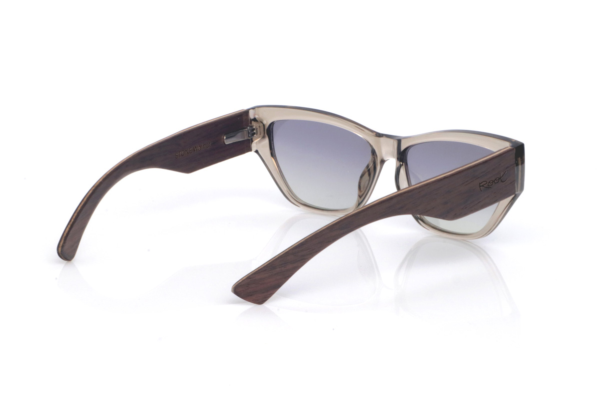 Wood eyewear of Walnut STONE. The STONE WALNUT wooden sunglasses combine a translucent “smoke/stone” front with a slightly cat-eye silhouette that subtly lifts the look. The transparency of the acetate reveals the nuances and joins of the frame, giving it a modern, lightweight feel.
The walnut temples are the standout feature: they visually balance the front, reinforce the sense of a solid, well-made piece, and add the warm contrast of natural wood grain. Their curved shape helps them sit securely, keeping them comfortable for everyday wear, with full UV protection.

Measurements: 145x45
Lens width: 55 for Wholesale & Retail | Root Sunglasses® 