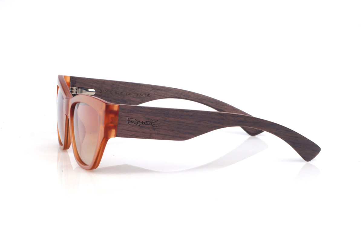 Wood eyewear of Walnut ASH. The ASH WALNUT sunglasses have a real “sunset” vibe: the translucent amber front makes the frame look lively and change with the light, with warm reflections that soften the overall look. The shape—somewhere between a soft cat-eye and a rectangle—is flattering and elongating.

The walnut temples add that natural, premium feel: the grain shows beautifully and contrasts with the front, and the wide temple design gives the profile more presence and a bolder, more solid look. It’s an easy, go-to pair for summer outfits—beach or city—with full UV protection.

Measurements: 145x45
Lens width (calibre): 55
 for Wholesale & Retail | Root Sunglasses® 
