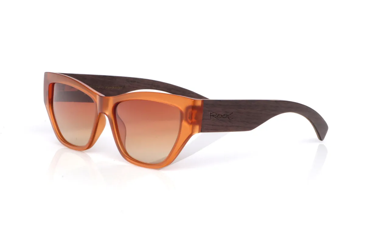 Gafas de Madera Natural de Walnut modelo ASH. Las ASH NOGAL tienen un aire muy “sunset”: el frontal en ámbar translúcido hace que la montura se vea viva y cambiante según la luz, con reflejos cálidos que suavizan el conjunto. La forma, entre cat-eye suave y rectangular, estiliza.
El nogal en las patillas suma ese punto natural y premium: la veta se nota y aporta contraste con el frontal, y el diseño ancho de la patilla le da presencia y un toque más contundente al perfil. Es un modelo muy agradecido para looks de verano, playa o ciudad, con protección completa frente a los rayos UV.

Medidas: 145x45
Calibre: 55 | Root Sunglasses® 