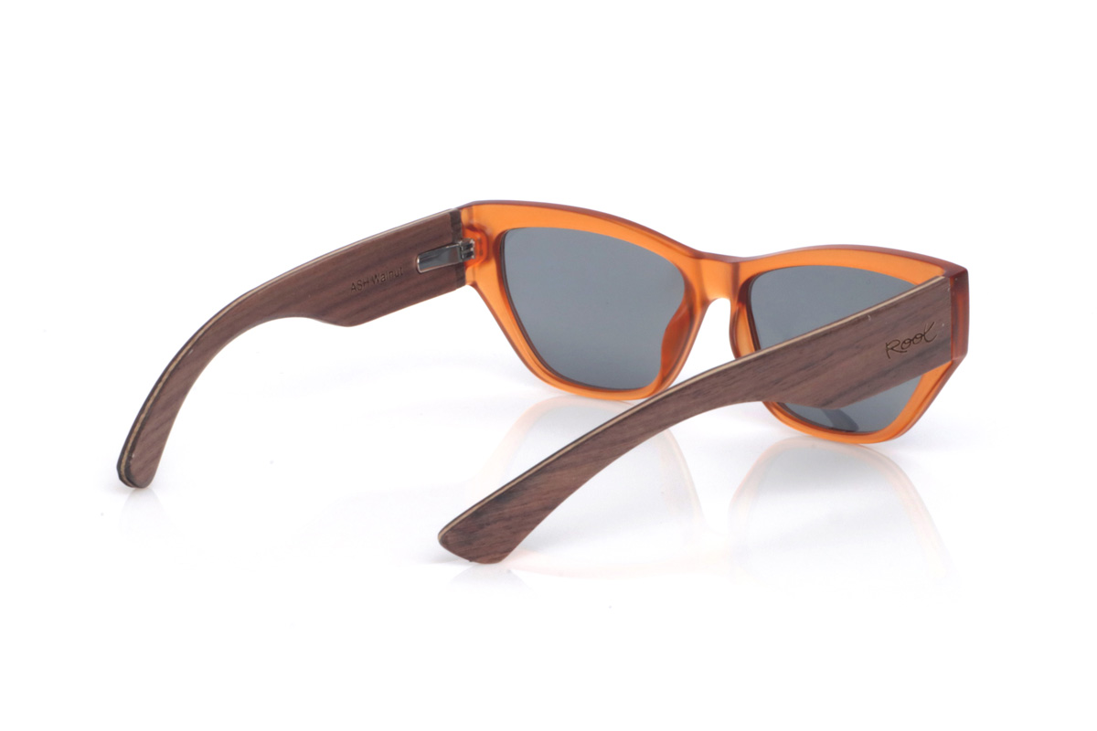Wood eyewear of Walnut ASH. The ASH WALNUT sunglasses have a real “sunset” vibe: the translucent amber front makes the frame look lively and change with the light, with warm reflections that soften the overall look. The shape—somewhere between a soft cat-eye and a rectangle—is flattering and elongating.

The walnut temples add that natural, premium feel: the grain shows beautifully and contrasts with the front, and the wide temple design gives the profile more presence and a bolder, more solid look. It’s an easy, go-to pair for summer outfits—beach or city—with full UV protection.

Measurements: 145x45
Lens width (calibre): 55
 for Wholesale & Retail | Root Sunglasses® 