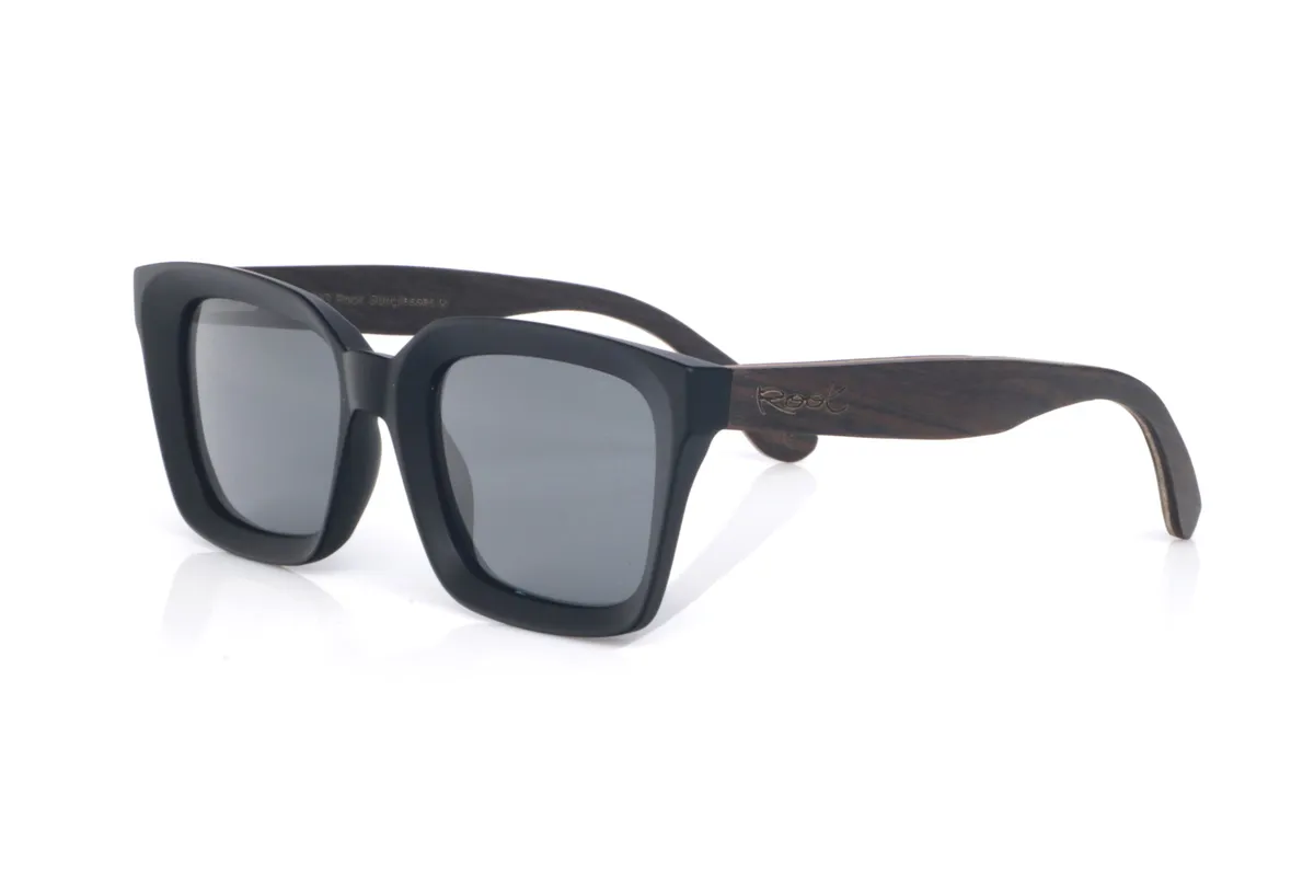 Gafas de Madera Natural de Roble modelo ASH 2. Las gafas de sol de madera ASH 2 apuestan por un frontal negro de líneas limpias y un aire “bold” que se nota nada más ponértelas con su forma cuadrada suave pero potente.
El contraste llega con las patillas de roble, que aportan calidez y ese toque orgánico. La madera se ve y se siente: veta natural, perfil  y una curvatura que ayuda a que asienten bien, dando una sensación de estabilidad. Protección completa frente a los rayos UV.

Medidas: 148x50
Calibre: 51
 | Root Sunglasses® 