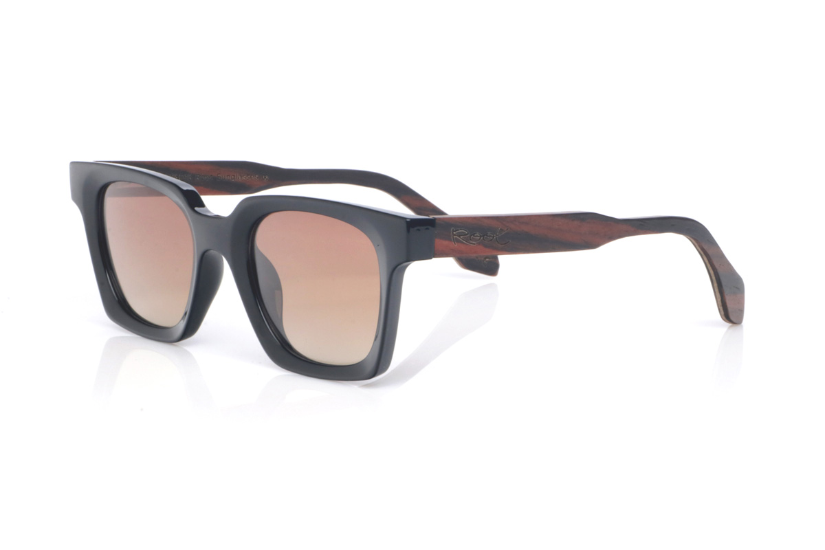 Gafas de Madera Natural de Ébano REEDUS. Las gafas de sol de madera REEDUS combinan un frontal negro profundo, de acabado brillante y líneas limpias, con una silueta rectangular de esquinas suavizadas que queda muy equilibrada en la cara. El puente tiene una curva marcada en la parte superior que le da un toque distintivo sin salir de un estilo clásico y muy ponible.  Varillas de ébano, elegantes y con veta natural visible según la pieza. Las REEDUS son un modelo cómodo, estable y muy versátil, con protección completa frente a los rayos UV.

Dimensiones: 142x47
Calibre: 47
 Venta al Por Mayor y Detalle | Root Sunglasses® 