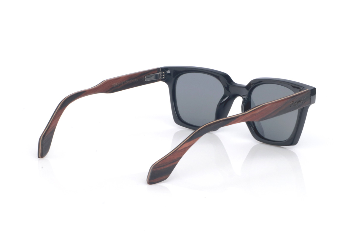 Gafas de Madera Natural de Ébano REEDUS. Las gafas de sol de madera REEDUS combinan un frontal negro profundo, de acabado brillante y líneas limpias, con una silueta rectangular de esquinas suavizadas que queda muy equilibrada en la cara. El puente tiene una curva marcada en la parte superior que le da un toque distintivo sin salir de un estilo clásico y muy ponible.  Varillas de ébano, elegantes y con veta natural visible según la pieza. Las REEDUS son un modelo cómodo, estable y muy versátil, con protección completa frente a los rayos UV.

Dimensiones: 142x47
Calibre: 47
 Venta al Por Mayor y Detalle | Root Sunglasses® 