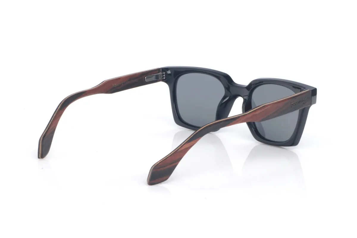 Gafas de Madera Natural de Ébano REEDUS. Las gafas de sol de madera REEDUS combinan un frontal negro profundo, de acabado brillante y líneas limpias, con una silueta rectangular de esquinas suavizadas que queda muy equilibrada en la cara. El puente tiene una curva marcada en la parte superior que le da un toque distintivo sin salir de un estilo clásico y muy ponible.  Varillas de ébano, elegantes y con veta natural visible según la pieza. Las REEDUS son un modelo cómodo, estable y muy versátil, con protección completa frente a los rayos UV.

Dimensiones: 142x47
Calibre: 47
 Venta al Por Mayor y Detalle | Root Sunglasses® 