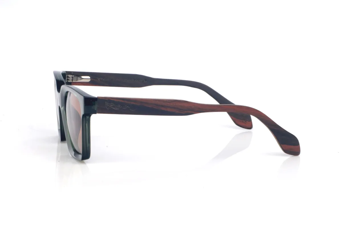 Gafas de Madera Natural de Ébano SEREN. Las gafas de sol de madera SEREN destacan por su frontal translúcido en tono verde profundo, con un acabado brillante y un diseño rectangular de esquinas suavizadas que resulta muy equilibrado y fácil de llevar. Los colores elegidos en las lentes refuerzan ese look natural y relajado, con un punto muy mediterráneo, ideal para combinar con todo sin perder personalidad.
Las varillas de ébano aportan el contraste elegante de la madera oscura, con vetas sutiles que hacen que cada pieza tenga matices propios. Un modelo cómodo y estable para el día a día, con protección completa frente a los rayos UV.

Dimensiones: 140x46
Calibre: 48 Venta al Por Mayor y Detalle | Root Sunglasses® 