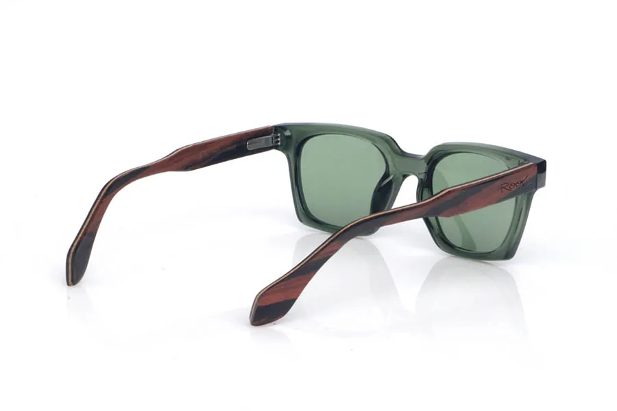 Gafas de Madera Natural de Ébano SEREN. Las gafas de sol de madera SEREN destacan por su frontal translúcido en tono verde profundo, con un acabado brillante y un diseño rectangular de esquinas suavizadas que resulta muy equilibrado y fácil de llevar. Los colores elegidos en las lentes refuerzan ese look natural y relajado, con un punto muy mediterráneo, ideal para combinar con todo sin perder personalidad.
Las varillas de ébano aportan el contraste elegante de la madera oscura, con vetas sutiles que hacen que cada pieza tenga matices propios. Un modelo cómodo y estable para el día a día, con protección completa frente a los rayos UV.

Dimensiones: 140x46
Calibre: 48 Venta al Por Mayor y Detalle | Root Sunglasses® 