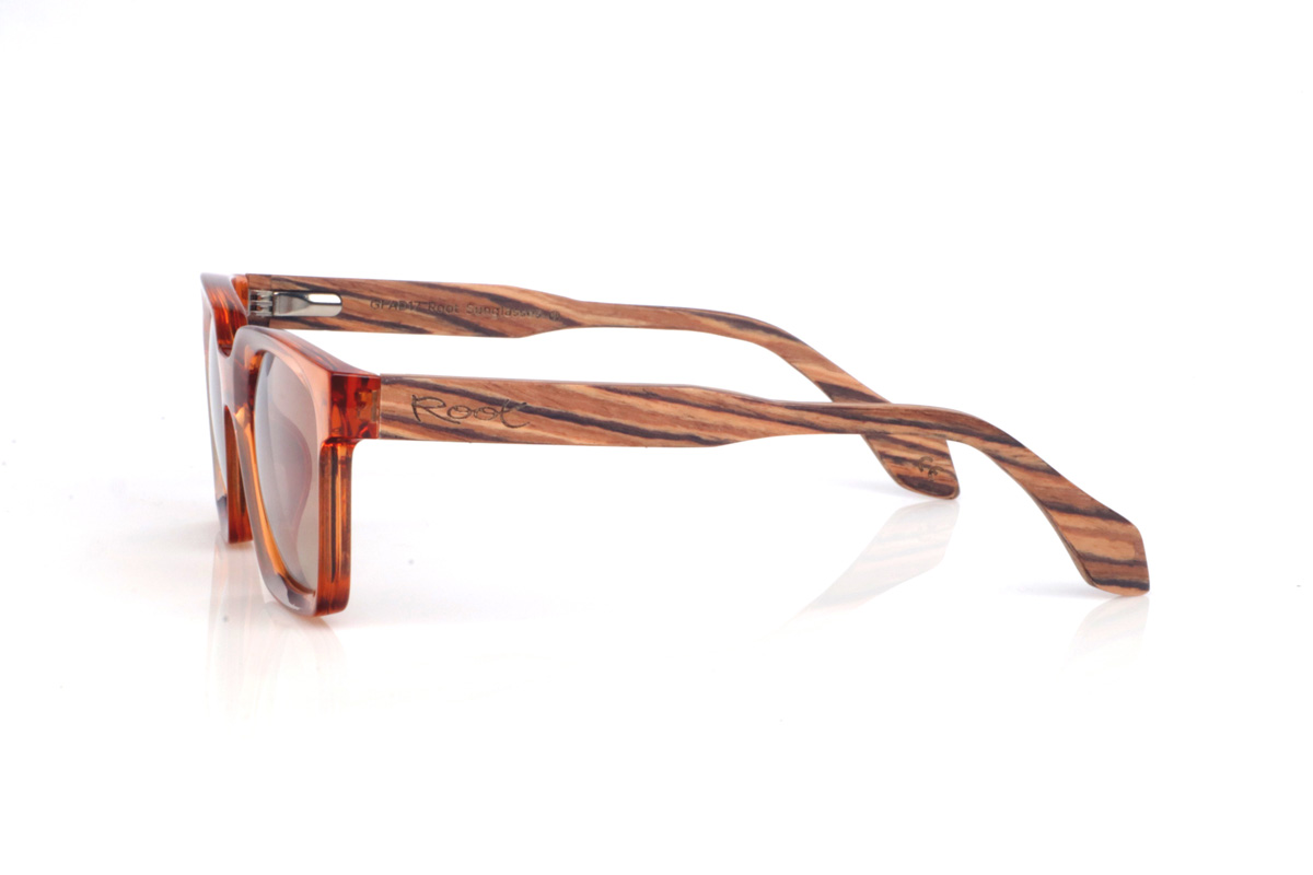 Wood eyewear of Zebrano IVY. The IVY wooden sunglasses combine a translucent amber/orange front, bright and eye-catching, with a softly contoured rectangular shape that feels balanced and flattering. The glossy finish enhances the colour and gives it a modern feel, perfect for summer looks.

Zebrano wood temples add a natural contrast with their distinctive striped grain, making each pair slightly unique. A bold, comfortable and versatile model for everyday wear, with full UV protection.

Dimensions: 140x46 mm
Lens width: 47
 for Wholesale & Retail | Root Sunglasses® 