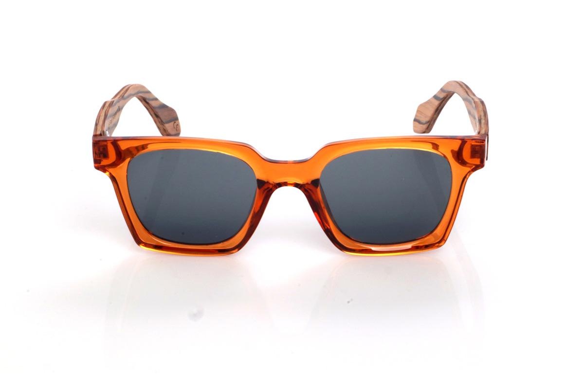 Wood eyewear of Zebrano IVY. The IVY wooden sunglasses combine a translucent amber/orange front, bright and eye-catching, with a softly contoured rectangular shape that feels balanced and flattering. The glossy finish enhances the colour and gives it a modern feel, perfect for summer looks.

Zebrano wood temples add a natural contrast with their distinctive striped grain, making each pair slightly unique. A bold, comfortable and versatile model for everyday wear, with full UV protection.

Dimensions: 140x46 mm
Lens width: 47
 for Wholesale & Retail | Root Sunglasses® 