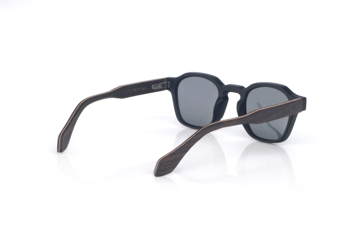 Wood eyewear of Oak LARK. The LARK wooden sunglasses combine a matte black front with clean lines and a soft-touch feel, paired with a well-balanced, timeless rounded-oval shape. The design stands out thanks to its straight bridge with a subtle upper step, adding character without feeling too much, and the right amount of thickness to give presence while keeping a light, modern look.

Black oak temples add the natural contrast of dark wood, with a discreet and elegant grain that makes each pair slightly unique. A comfortable and highly versatile model for everyday wear, with full UV protection.

Dimensions: 145x46 mm
Lens width: 46
 for Wholesale & Retail | Root Sunglasses® 