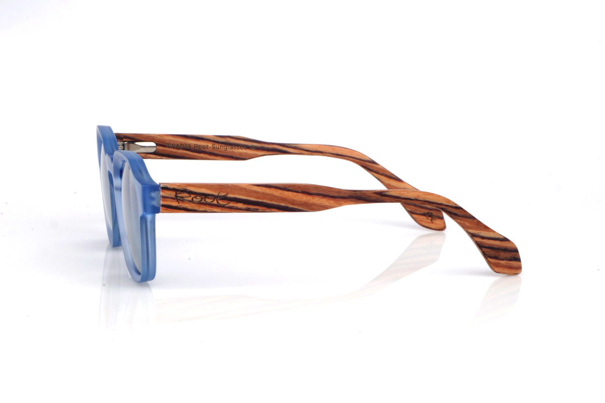 Wood eyewear of Zebrano LILY. The LILY wooden sunglasses combine a translucent light-blue front, fresh and very on-trend, with a rounded-oval shape and soft lines that feels comfortable and easy to wear. The satin/translucent finish adds a light, luminous touch, ideal for a relaxed style with personality.

Zebrano wood temples add contrast and warmth thanks to their distinctive striped grain, creating a very original mix of colour and natural wood. A versatile model for everyday wear, with full UV protection.

Dimensions: 144x46 mm
Lens width: 46
 for Wholesale & Retail | Root Sunglasses® 