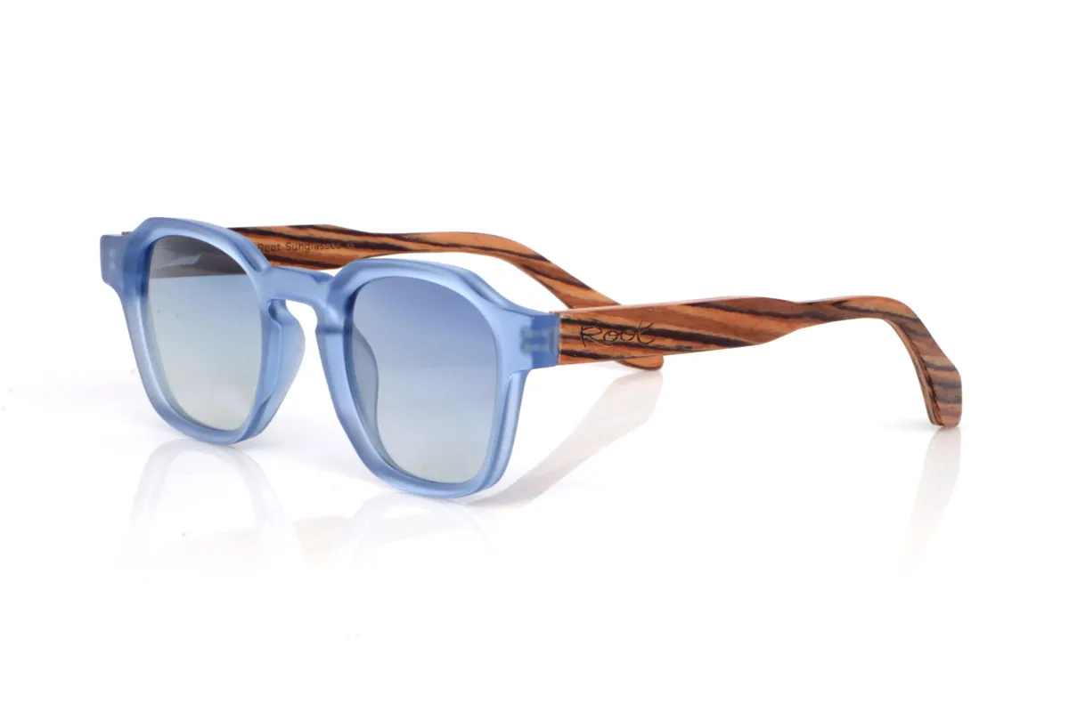 Gafas de Madera Natural de Zebrano modelo LILY. Las gafas de sol de madera LILY combinan un frontal translúcido en azul claro, fresco y muy actual, con una silueta redondeada-ovalada de líneas suaves que resulta cómoda y muy fácil de llevar. El acabado satinado/translúcido aporta un toque ligero y luminoso, ideal para un estilo relajado con personalidad.

Las varillas de madera zebrano suman contraste y calidez gracias a su veta rayada tan característica, creando una mezcla muy original entre color y madera natural. Un modelo versátil para el día a día, con protección completa frente a los rayos UV.

Dimensiones: 144x46
Calibre: 46
 | Root Sunglasses® 