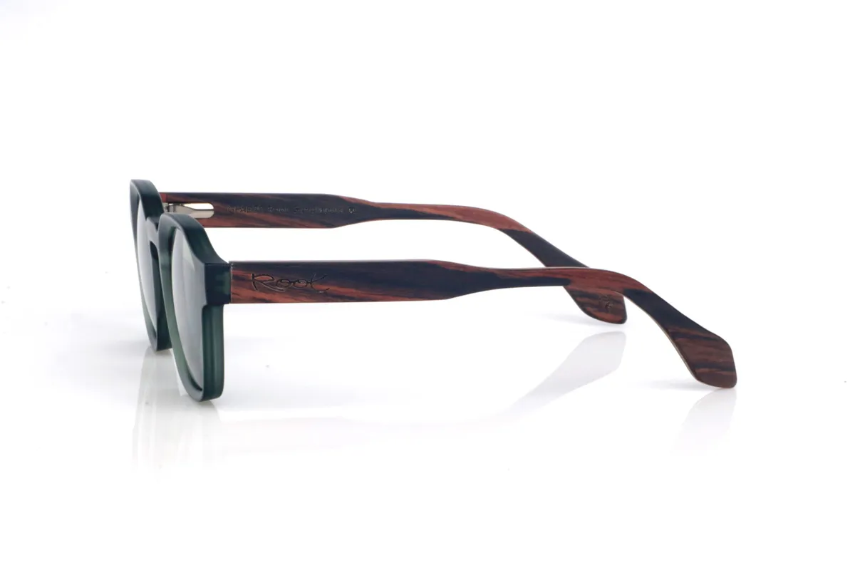 Gafas de Madera Natural de Ébano JADE. Las gafas de sol de madera JADE combinan un frontal translúcido en verde profundo, con un acabado satinado muy agradable, y una silueta redondeada-ovalada de líneas suaves que resulta equilibrada y fácil de llevar. El puente tipo keyhole (con abertura suave) aporta un toque clásico con personalidad, manteniendo un look limpio y muy actual.

Las varillas de ébano añaden el contraste elegante de la madera oscura, con vetas sutiles que hacen que cada pieza tenga matices propios. Un modelo cómodo y versátil para el día a día, con protección completa frente a los rayos UV.

Dimensiones: 144x46
Calibre: 46
 Venta al Por Mayor y Detalle | Root Sunglasses® 