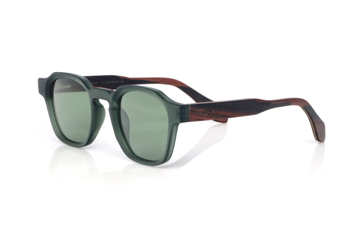 Gafas de Madera Natural de Ébano modelo JADE. Las gafas de sol de madera JADE combinan un frontal translúcido en verde profundo, con un acabado satinado muy agradable, y una silueta redondeada-ovalada de líneas suaves que resulta equilibrada y fácil de llevar. El puente tipo keyhole (con abertura suave) aporta un toque clásico con personalidad, manteniendo un look limpio y muy actual.

Las varillas de ébano añaden el contraste elegante de la madera oscura, con vetas sutiles que hacen que cada pieza tenga matices propios. Un modelo cómodo y versátil para el día a día, con protección completa frente a los rayos UV.

Dimensiones: 144x46
Calibre: 46
 | Root Sunglasses® 