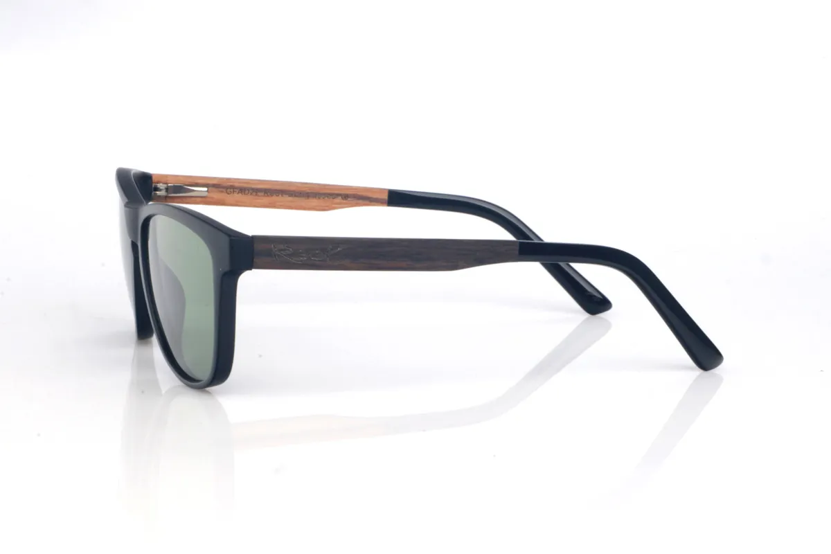 Gafas de Madera Natural de Roble AIDEN. Las gafas de sol de madera AIDEN combinan un frontal negro de acabado suave con una silueta ligeramente envolvente que equilibra presencia y comodidad. El diseño tiene líneas limpias y un contorno estilizado, con una forma entre rectangular y ovalada que favorece y resulta muy fácil de llevar en el día a día. El puente con abertura suave aporta un toque clásico y funcional, manteniendo un look moderno y sobrio.

Las varillas de roble negro añaden el contraste natural de la madera oscura, con una veta discreta que hace que cada pieza tenga matices propios. Un modelo versátil, cómodo y estable, pensado para acompañarte a diario con protección completa frente a los rayos UV.

Dimensiones: 141x49
Calibre: 54
 Venta al Por Mayor y Detalle | Root Sunglasses® 