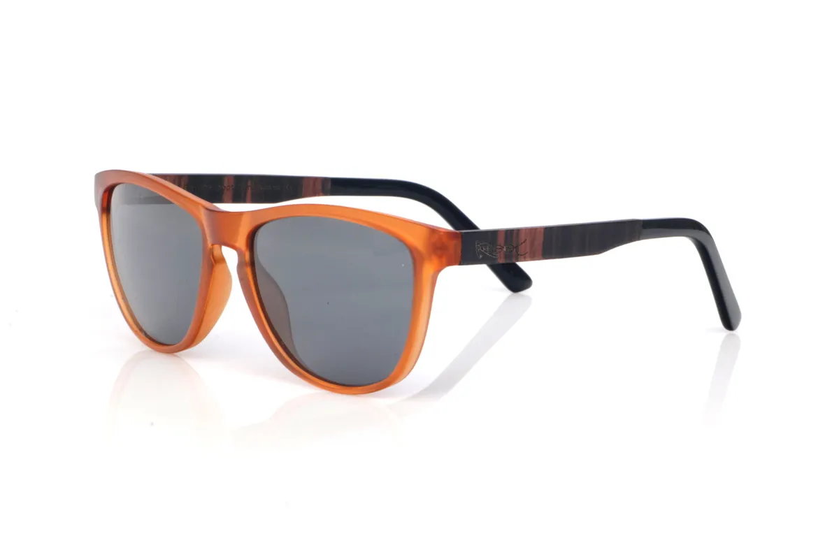 Gafas de Madera Natural de Ébano modelo DECLAN OR. Las gafas de sol de madera DECLAN OR combinan un frontal translúcido en tono ámbar, muy luminoso y con un aire retro muy actual, con una silueta suavemente envolvente que resulta cómoda y favorecedora. El diseño mantiene líneas limpias y un contorno estilizado, con una forma entre rectangular y ovalada que se adapta muy bien a distintos tipos de rostro. El puente con abertura suave añade un toque clásico sin perder ese punto moderno y veraniego.

Las varillas de ébano aportan un contraste elegante y más oscuro, con una veta vertical marcada que se aprecia en el lateral y hace que cada pieza tenga un patrón ligeramente distinto. Además, el extremo de la varilla va rematado en acetato, aportando un acabado más pulido y una sensación muy cómoda en la zona de la oreja. Un modelo versátil para el día a día, con protección completa frente a los rayos UV.

Dimensiones: 141x49
Calibre: 54
 | Root Sunglasses® 