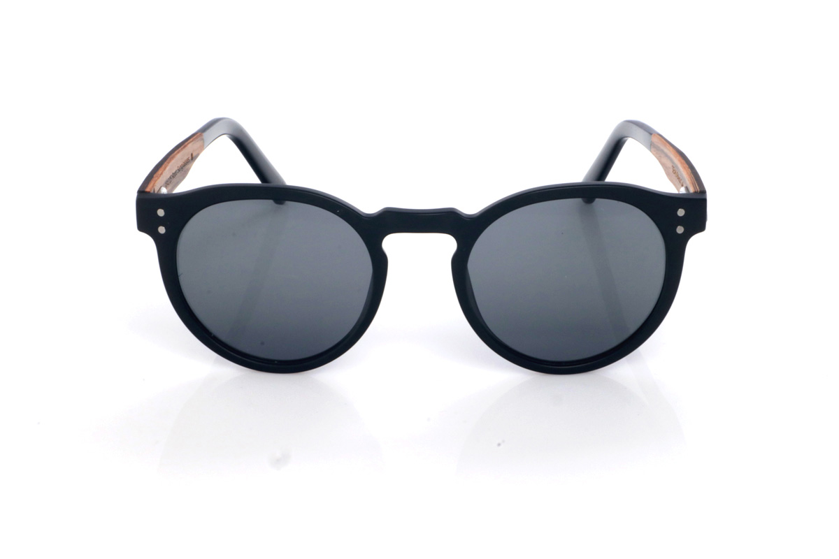 Gafas de Madera Natural de Roble SEAN B. Las gafas de sol SEAN combinan un frontal negro mate con una silueta redondeada y atemporal, equilibrada y muy fácil de llevar. El diseño destaca por su puente suavemente perfilado y un contorno limpio, con el grosor justo para dar presencia manteniendo un look ligero y moderno.

Las varillas de roble negro aportan un contraste natural y elegante, y el interior de la varilla está terminado en walnut, añadiendo un detalle cálido y un sutil efecto bicolor 

Dimensiones: 142x52 mm
Calibre: 49
 Venta al Por Mayor y Detalle | Root Sunglasses® 