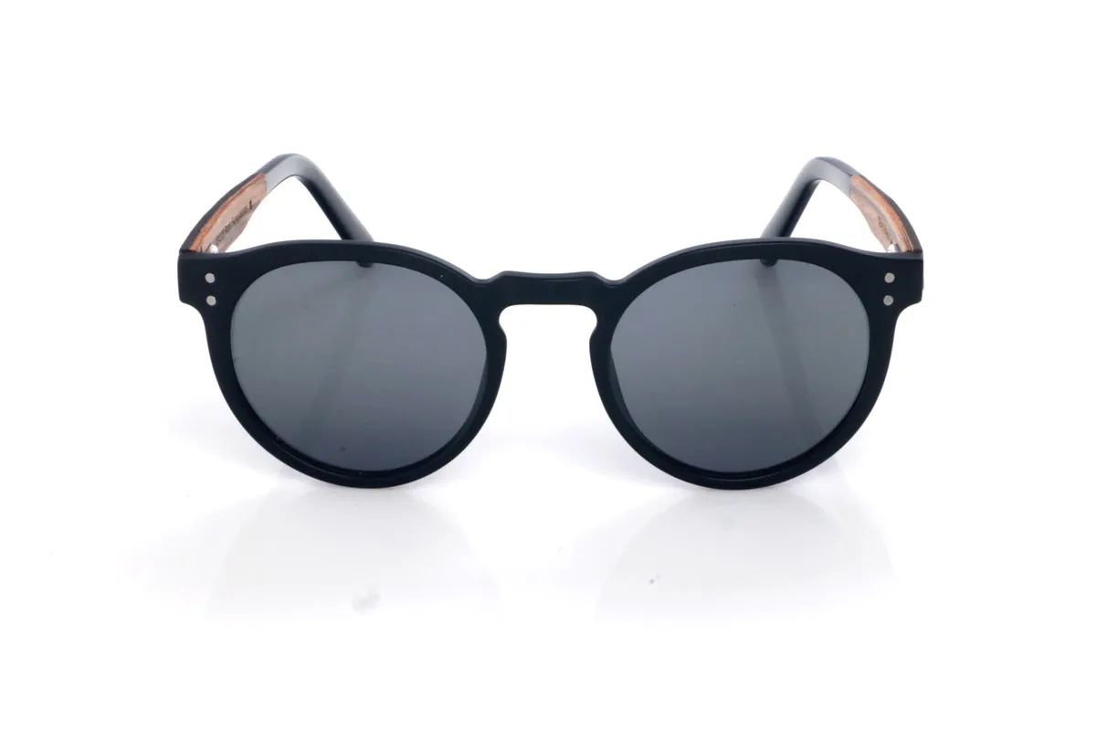 Gafas de Madera Natural de Roble SEAN B. Las gafas de sol SEAN combinan un frontal negro mate con una silueta redondeada y atemporal, equilibrada y muy fácil de llevar. El diseño destaca por su puente suavemente perfilado y un contorno limpio, con el grosor justo para dar presencia manteniendo un look ligero y moderno.

Las varillas de roble negro aportan un contraste natural y elegante, y el interior de la varilla está terminado en walnut, añadiendo un detalle cálido y un sutil efecto bicolor 

Dimensiones: 142x52 mm
Calibre: 49
 Venta al Por Mayor y Detalle | Root Sunglasses® 