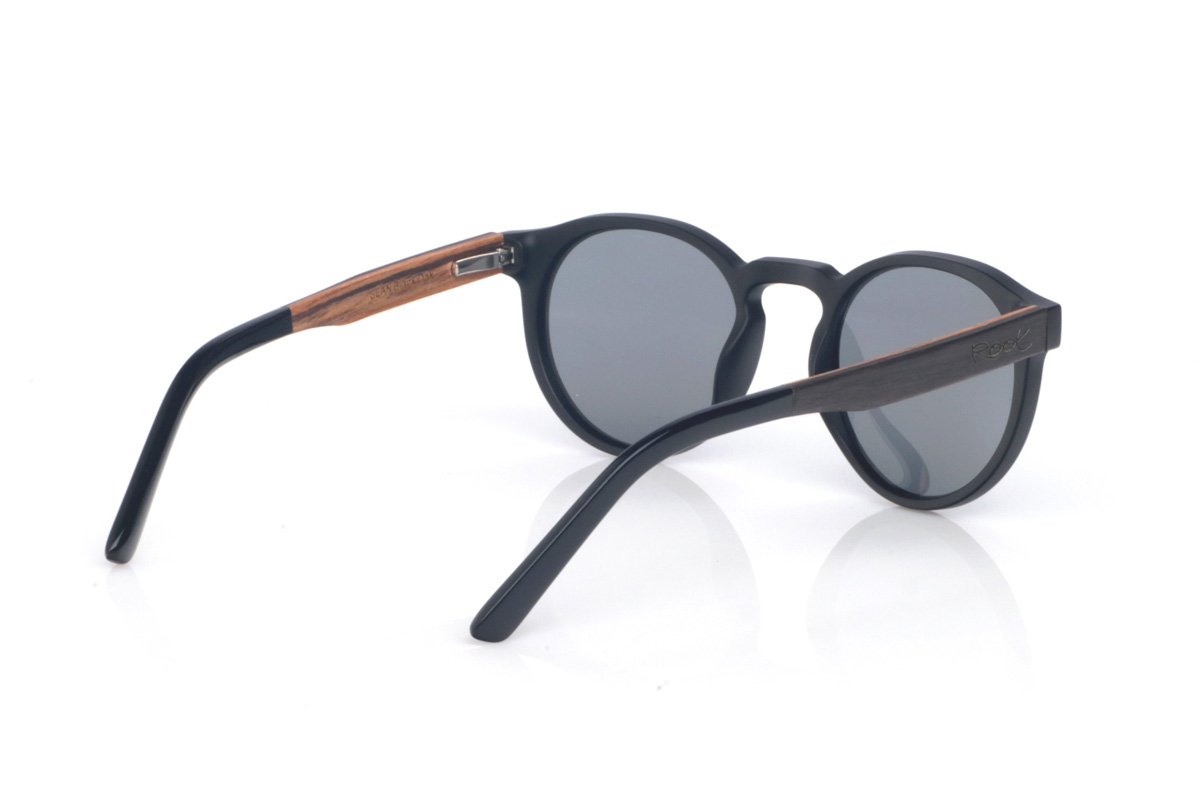 Gafas de Madera Natural de Roble SEAN B. Las gafas de sol SEAN combinan un frontal negro mate con una silueta redondeada y atemporal, equilibrada y muy fácil de llevar. El diseño destaca por su puente suavemente perfilado y un contorno limpio, con el grosor justo para dar presencia manteniendo un look ligero y moderno.

Las varillas de roble negro aportan un contraste natural y elegante, y el interior de la varilla está terminado en walnut, añadiendo un detalle cálido y un sutil efecto bicolor 

Dimensiones: 142x52 mm
Calibre: 49
 Venta al Por Mayor y Detalle | Root Sunglasses® 