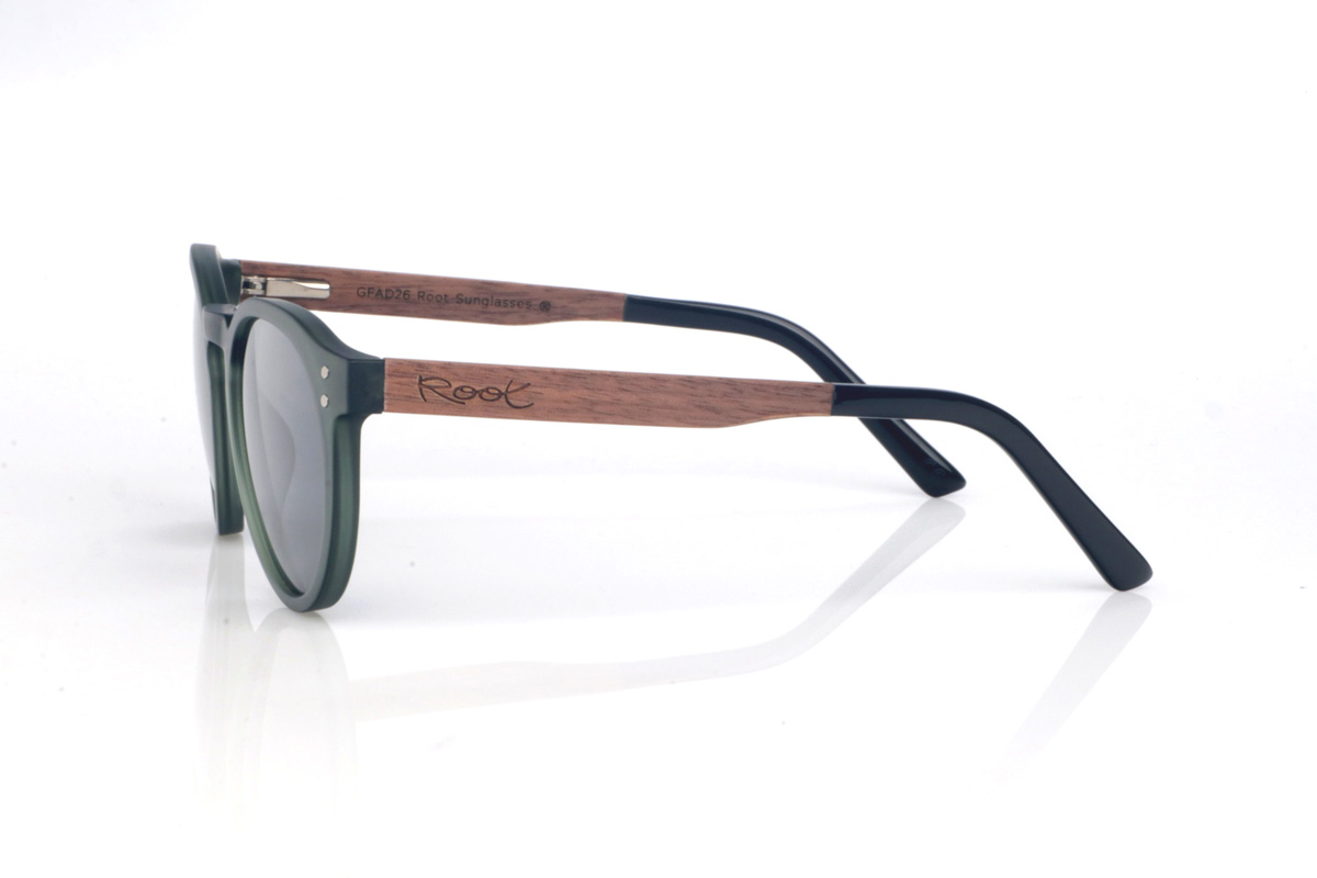 Gafas de Madera Natural de Walnut SEAN GR. Las gafas de sol de madera SEAN combinan un frontal translúcido en verde profundo, con acabado satinado y una silueta redondeada muy equilibrada y fácil de llevar. El puente suavemente marcado y los pequeños remaches laterales le dan un toque clásico con personalidad, manteniendo un look limpio y actual.

Las varillas son bicolor: madera de ébano por fuera y un interior en walnut que aporta un contraste cálido y muy elegante. Además, la patilla termina en acetato negro, para un acabado más cómodo.

Dimensiones: 142x52 mm
Calibre: 49
 Venta al Por Mayor y Detalle | Root Sunglasses® 