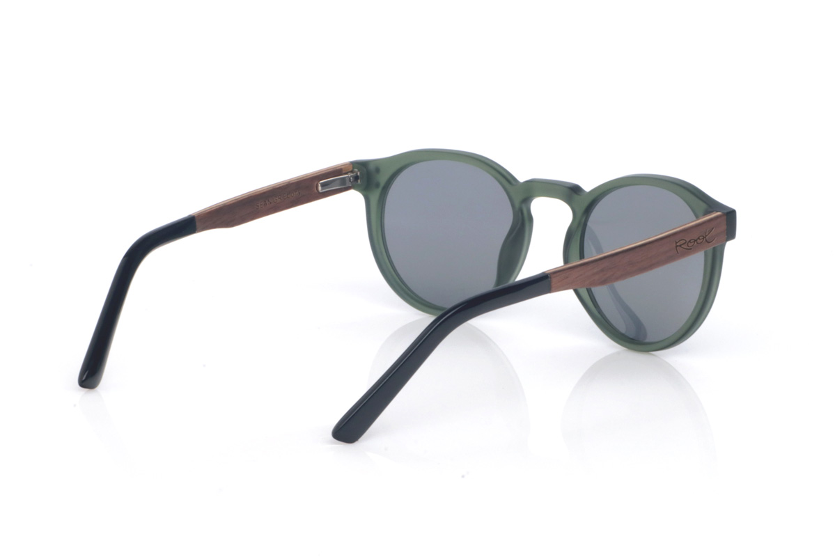 Gafas de Madera Natural de Walnut SEAN GR. Las gafas de sol de madera SEAN combinan un frontal translúcido en verde profundo, con acabado satinado y una silueta redondeada muy equilibrada y fácil de llevar. El puente suavemente marcado y los pequeños remaches laterales le dan un toque clásico con personalidad, manteniendo un look limpio y actual.

Las varillas son bicolor: madera de ébano por fuera y un interior en walnut que aporta un contraste cálido y muy elegante. Además, la patilla termina en acetato negro, para un acabado más cómodo.

Dimensiones: 142x52 mm
Calibre: 49
 Venta al Por Mayor y Detalle | Root Sunglasses® 