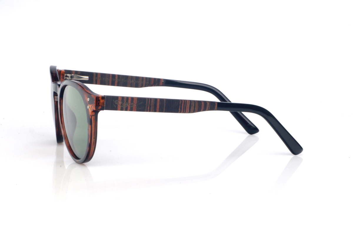 Gafas de Madera Natural de Ébano SEAN CAR. Las gafas de sol de madera SEAN CAR combinan un frontal translúcido en tono carey/caramelo con una silueta redondeada y atemporal, muy equilibrada y fácil de llevar. El puente suavemente definido y los pequeños remaches metálicos del frontal aportan un toque clásico con personalidad, manteniendo un look limpio y actual.

Las varillas son bicolor: ébano por fuera y un interior en walnut que añade un contraste cálido y elegante. Además, la patilla termina en acetato negro para un extra de comodidad y un acabado más refinado.

Dimensiones: 142x52 mm
Calibre: 49
 Venta al Por Mayor y Detalle | Root Sunglasses® 