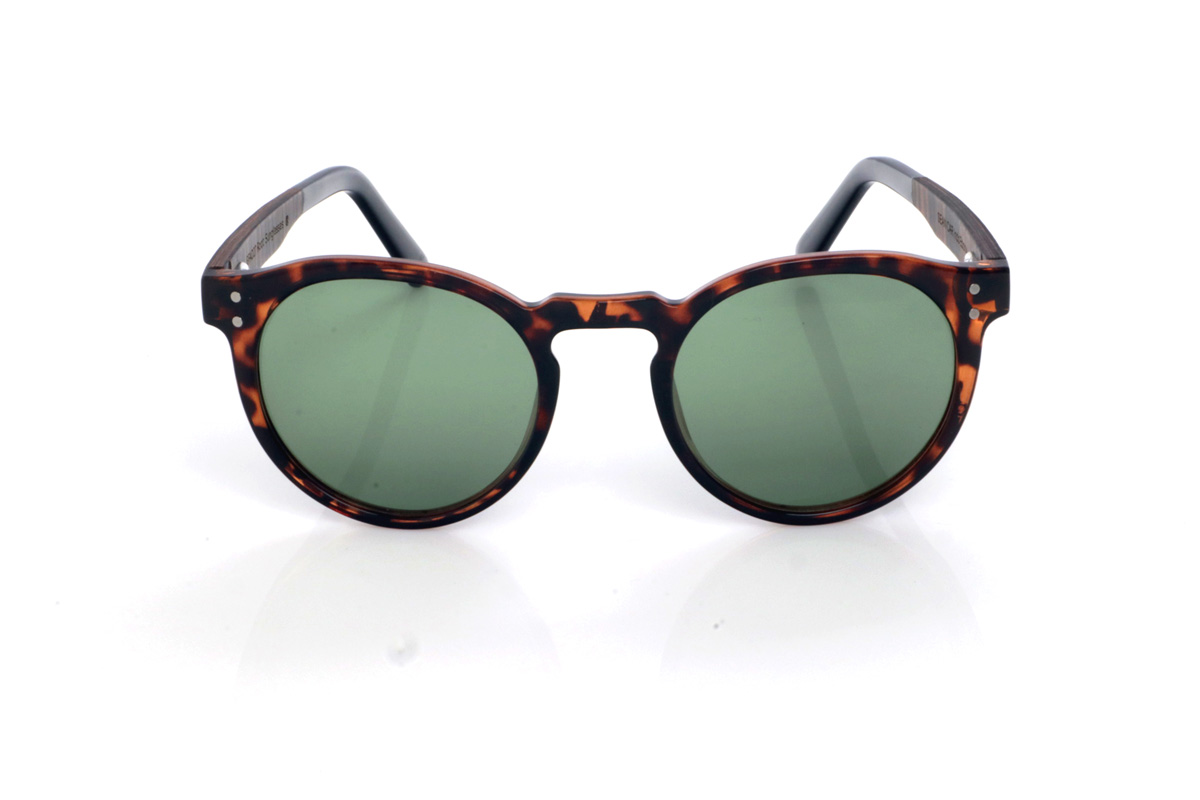 Gafas de Madera Natural de Ébano SEAN CAR. Las gafas de sol de madera SEAN CAR combinan un frontal translúcido en tono carey/caramelo con una silueta redondeada y atemporal, muy equilibrada y fácil de llevar. El puente suavemente definido y los pequeños remaches metálicos del frontal aportan un toque clásico con personalidad, manteniendo un look limpio y actual.

Las varillas son bicolor: ébano por fuera y un interior en walnut que añade un contraste cálido y elegante. Además, la patilla termina en acetato negro para un extra de comodidad y un acabado más refinado.

Dimensiones: 142x52 mm
Calibre: 49
 Venta al Por Mayor y Detalle | Root Sunglasses® 