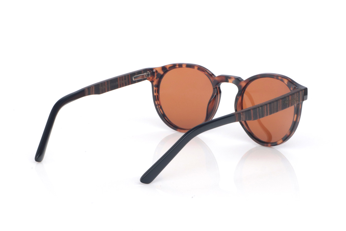 Gafas de Madera Natural de Ébano SEAN CAR. Las gafas de sol de madera SEAN CAR combinan un frontal translúcido en tono carey/caramelo con una silueta redondeada y atemporal, muy equilibrada y fácil de llevar. El puente suavemente definido y los pequeños remaches metálicos del frontal aportan un toque clásico con personalidad, manteniendo un look limpio y actual.

Las varillas son bicolor: ébano por fuera y un interior en walnut que añade un contraste cálido y elegante. Además, la patilla termina en acetato negro para un extra de comodidad y un acabado más refinado.

Dimensiones: 142x52 mm
Calibre: 49
 Venta al Por Mayor y Detalle | Root Sunglasses® 