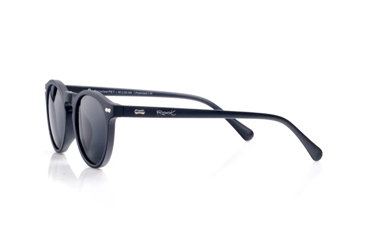 Wood eyewear of Pet LANTANA. LANTANA sunglasses are made from recycled PET plastic, transforming bottles into a lightweight, durable, and contemporary frame. Their rounded shape with a keyhole bridge lends a flattering, classic look that's easy to pair with both urban and more relaxed outfits. The matte black frame emphasizes the clean lines of the design and highlights the small metallic details on the front and temples, reinforcing its modern and sustainable character. The thin, slightly curved temples fit comfortably on the head, offering a stable fit all day long. Equipped with high-quality polarized lenses, LANTANA sunglasses reduce glare and protect your eyes from UV rays, making them ideal recycled sunglasses for those seeking a unisex essential with plenty of personality and a commitment to the planet. Dimensions: 138 x 47 mm. Lens width: 48 for Wholesale & Retail | Root Sunglasses® 