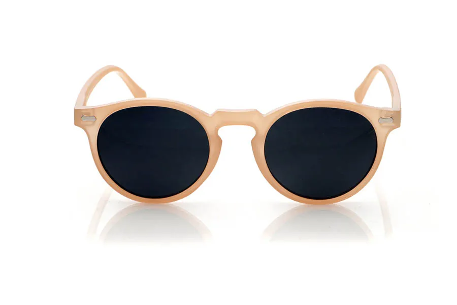 Wood eyewear of Pet KENTIA. KENTIA sunglasses are made from recycled PET plastic, giving bottles a new life and transforming them into lightweight, durable frames with a modern style. Their rounded shape with a keyhole bridge softens facial features and adds a fresh, casual look, perfect for everyday wear. The translucent finish in a soft, warm tone allows a glimpse of the frame's interior, reinforcing its personality and sustainable essence. Small metallic details on the front and temples add a distinctive touch without disrupting the design's harmony. The thin, curved temples fit comfortably on the head, ensuring a secure fit for hours. Equipped with high-quality polarized lenses, KENTIA sunglasses reduce glare and protect your eyes from UV rays, making them ideal recycled sunglasses for those seeking style, comfort, and respect for the planet all in one. Dimensions: 139 x 48 mm. Lens width: 48 mm. for Wholesale & Retail | Root Sunglasses® 
