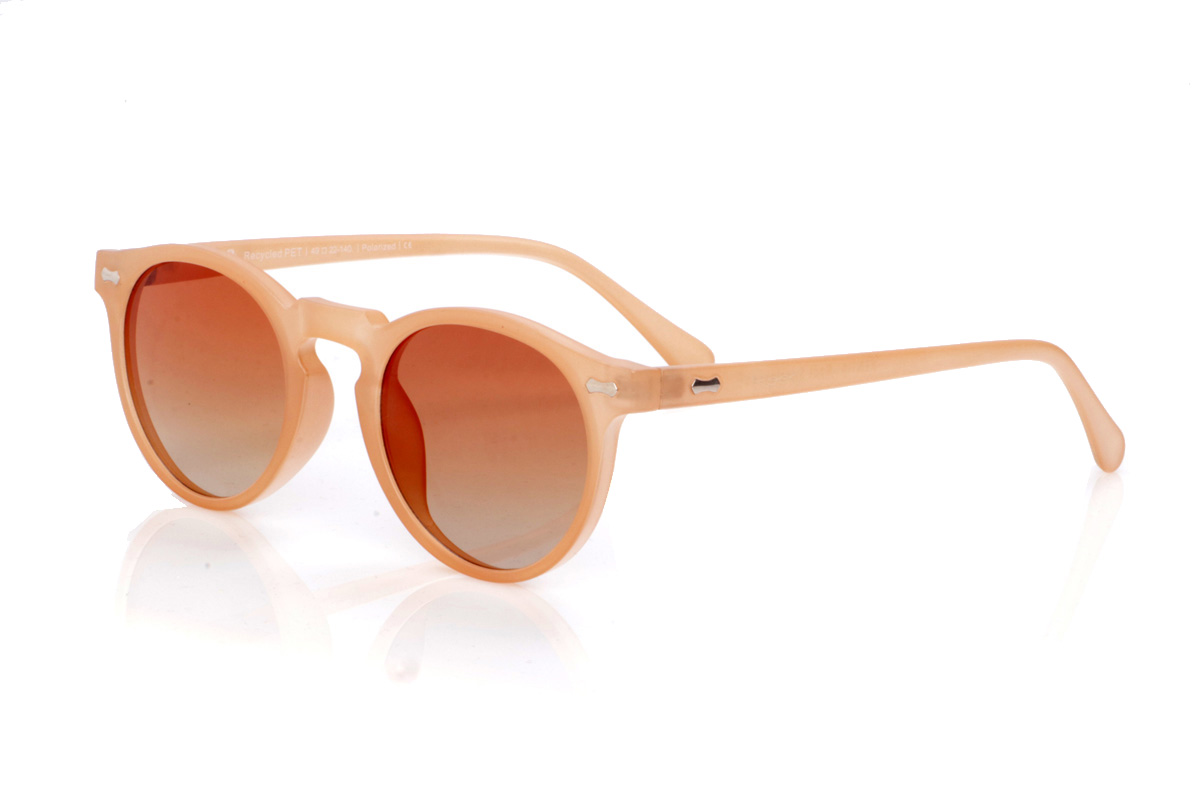 Gafas de Madera Natural de Pet modelo KENTIA. Las gafas de sol KENTIA están fabricadas en plástico PET reciclado, dando una nueva vida a las botellas para convertirlas en una montura ligera, resistente y con un carácter muy actual. Su forma redondeada con puente tipo “keyhole” suaviza las facciones y aporta un aire fresco y desenfadado, perfecto para el día a día. El acabado translúcido en un tono suave y cálido deja entrever el interior de la montura, reforzando su personalidad y su esencia sostenible. Los pequeños detalles metálicos en el frontal y las varillas añaden un toque distintivo sin romper la armonía del diseño. Las varillas finas y curvadas se adaptan cómodamente a la cabeza, garantizando un ajuste seguro durante horas. Equipadas con lentes polarizadas de alta calidad, las KENTIA reducen los reflejos y protegen tus ojos frente a los rayos UV, convirtiéndose en unas gafas recicladas ideales para quienes buscan estilo, comodidad y respeto por el planeta en una sola pieza. Dimensiones: 139x48mm. Calibre: 48
 | Root Sunglasses® 