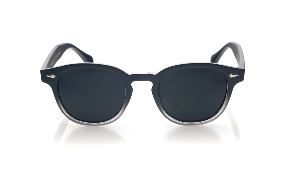 Wood eyewear of Pet JACINT. The JACINT sunglasses are made from recycled PET plastic, transforming waste into a robust and lightweight frame with a distinctly urban style. Their slightly square shape with soft edges and a keyhole bridge lends a contemporary look that flatters all face shapes. The front combines a dark finish with a subtle translucent gradient at the bottom, revealing the material beneath and reinforcing the modern and sustainable character of the design. Metal accents on the front and temples add a distinctive touch without overwhelming the frame. The wide, clean-lined, and well-balanced temples fit comfortably on the head, offering a stable fit all day long. Equipped with high-quality polarized lenses, the JACINT sunglasses reduce glare and protect your eyes from UV rays, making them the perfect recycled sunglasses for those seeking a unisex essential with personality and a commitment to the planet. Dimensions: 143 x 48 mm. Lens width: 48 mm. for Wholesale & Retail | Root Sunglasses® 