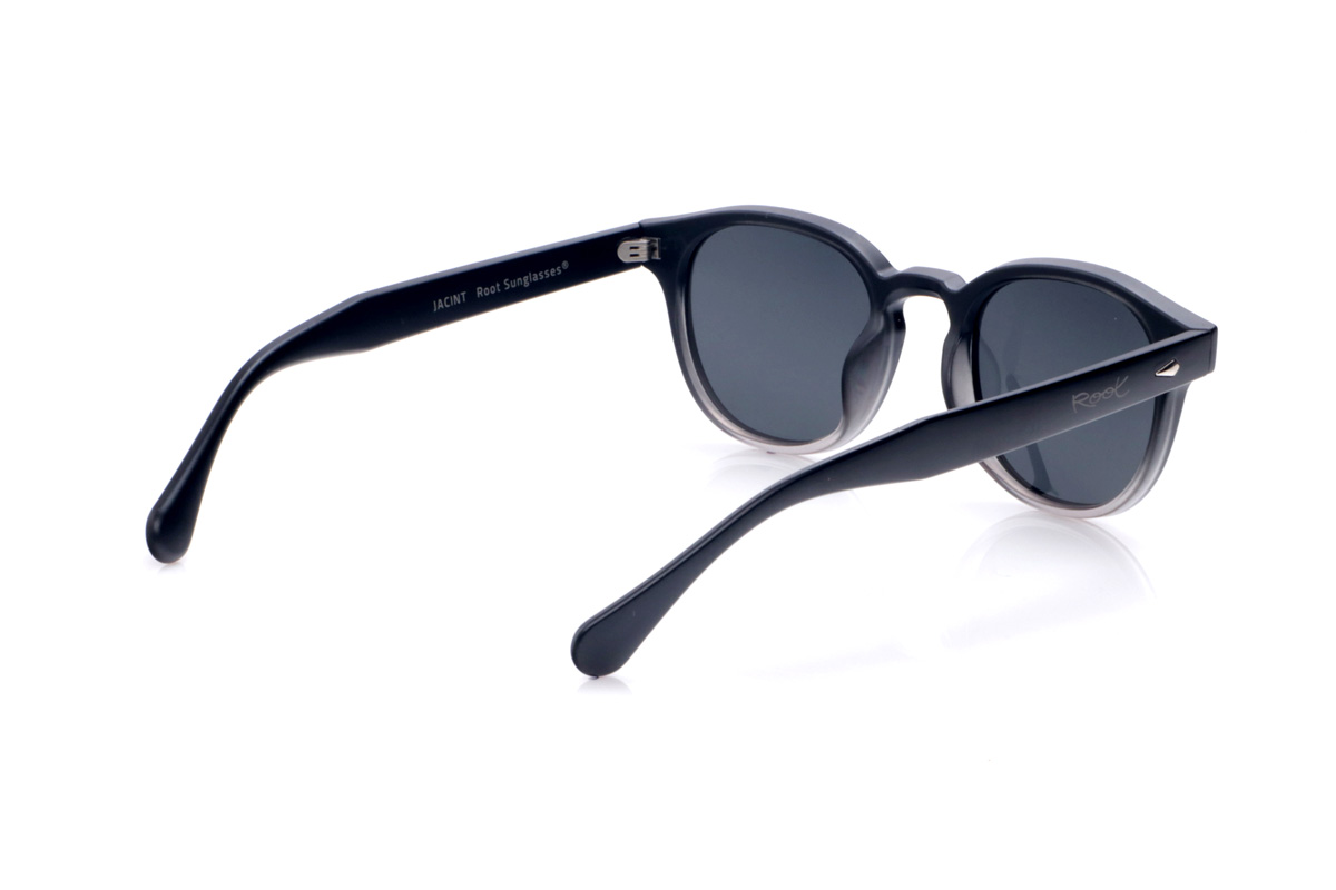 Gafas de Madera Natural de Pet JACINT. Las JACINT están fabricadas en plástico PET reciclado, transformando residuos en una montura robusta y ligera con un marcado estilo urbano. Su forma ligeramente cuadrada con bordes suaves y puente tipo “keyhole” aporta un aire contemporáneo muy favorecedor para todo tipo de rostros. El frontal combina un acabado oscuro con un sutil degradado translúcido en la parte inferior, que deja entrever el interior del material y refuerza el carácter moderno y sostenible del diseño. Los apliques metálicos en el frontal y las varillas añaden un toque distintivo sin recargar la montura. Las varillas anchas, de líneas limpias y bien equilibradas, se adaptan cómodamente a la cabeza, ofreciendo un ajuste estable durante todo el día. Equipadas con lentes polarizadas de alta calidad, las JACINT reducen los reflejos y protegen tus ojos frente a los rayos UV, convirtiéndose en unas gafas recicladas perfectas para quienes buscan un básico unisex con personalidad y compromiso con el planeta. Dimensiones: 143x48mm Calibre:48
 Venta al Por Mayor y Detalle | Root Sunglasses® 