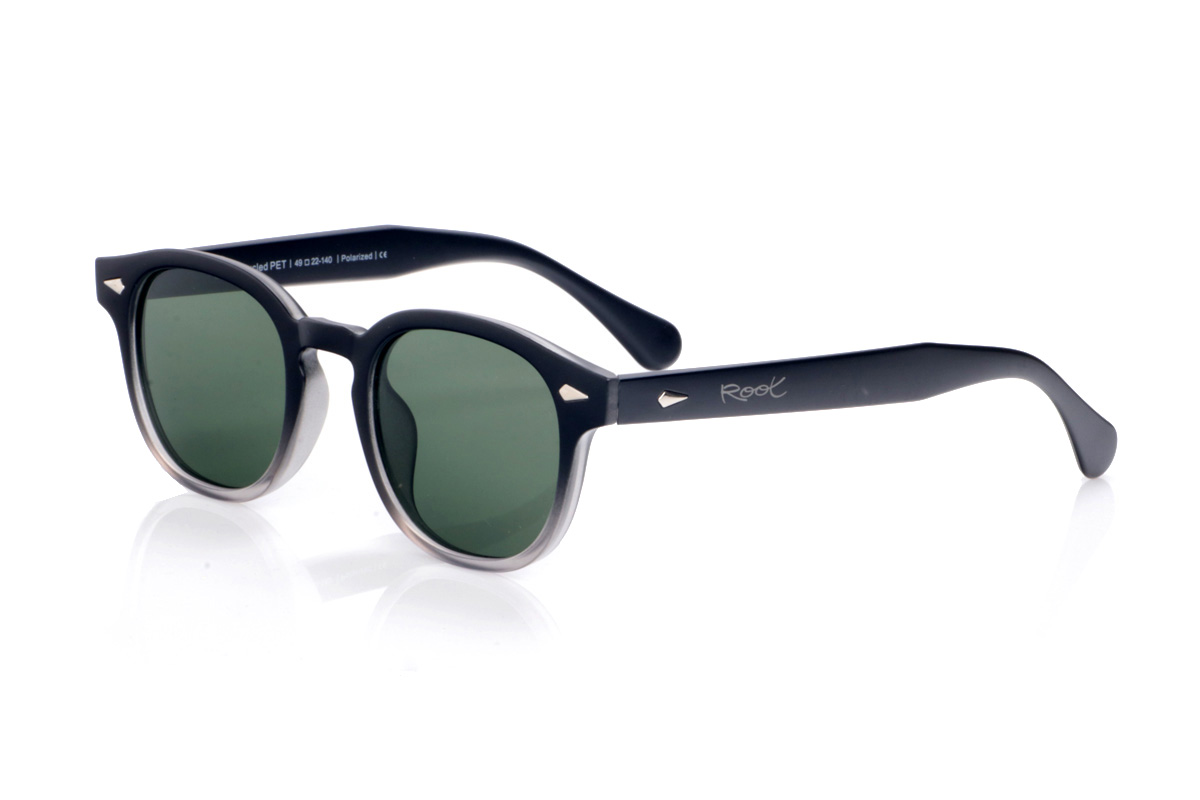 Gafas de Madera Natural de Pet modelo JACINT. Las JACINT están fabricadas en plástico PET reciclado, transformando residuos en una montura robusta y ligera con un marcado estilo urbano. Su forma ligeramente cuadrada con bordes suaves y puente tipo “keyhole” aporta un aire contemporáneo muy favorecedor para todo tipo de rostros. El frontal combina un acabado oscuro con un sutil degradado translúcido en la parte inferior, que deja entrever el interior del material y refuerza el carácter moderno y sostenible del diseño. Los apliques metálicos en el frontal y las varillas añaden un toque distintivo sin recargar la montura. Las varillas anchas, de líneas limpias y bien equilibradas, se adaptan cómodamente a la cabeza, ofreciendo un ajuste estable durante todo el día. Equipadas con lentes polarizadas de alta calidad, las JACINT reducen los reflejos y protegen tus ojos frente a los rayos UV, convirtiéndose en unas gafas recicladas perfectas para quienes buscan un básico unisex con personalidad y compromiso con el planeta. Dimensiones: 143x48mm Calibre:48
 | Root Sunglasses® 