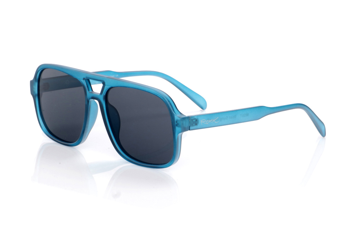 Gafas de Madera Natural de Pet modelo MOUT. Las gafas de sol MOUT están fabricadas en plástico PET reciclado, transformando botellas en una montura ligera y resistente con marcado carácter deportivo. Su frontal rectangular de tamaño medio-grande, con doble puente integrado, aporta un aire retro inspirado en las gafas de aviador, mientras que el acabado translúcido en azul intenso les da frescura y un estilo muy actual. Las líneas definidas de la montura se equilibran con varillas finas y curvadas que se adaptan cómodamente a la cabeza, ofreciendo buen agarre sin presionar. Equipadas con lentes polarizadas de alta calidad, reducen reflejos y deslumbramientos y protegen totalmente frente a los rayos UV, convirtiendo a las MOUT en unas gafas recicladas ideales para quienes buscan comodidad, personalidad y compromiso con el planeta en una sola pieza. Dimensiones: 149x54mm; Calibre 57
 | Root Sunglasses® 