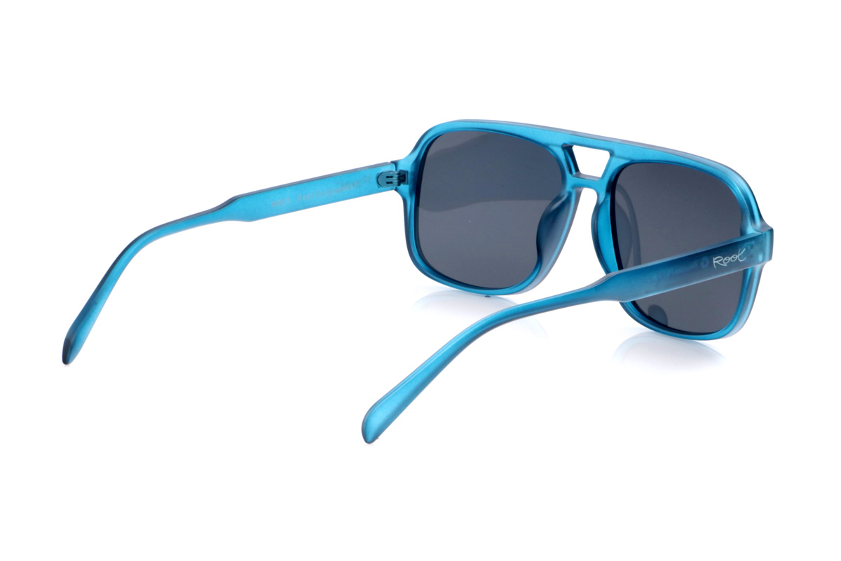 Gafas de Madera Natural de Pet MOUT. Las gafas de sol MOUT están fabricadas en plástico PET reciclado, transformando botellas en una montura ligera y resistente con marcado carácter deportivo. Su frontal rectangular de tamaño medio-grande, con doble puente integrado, aporta un aire retro inspirado en las gafas de aviador, mientras que el acabado translúcido en azul intenso les da frescura y un estilo muy actual. Las líneas definidas de la montura se equilibran con varillas finas y curvadas que se adaptan cómodamente a la cabeza, ofreciendo buen agarre sin presionar. Equipadas con lentes polarizadas de alta calidad, reducen reflejos y deslumbramientos y protegen totalmente frente a los rayos UV, convirtiendo a las MOUT en unas gafas recicladas ideales para quienes buscan comodidad, personalidad y compromiso con el planeta en una sola pieza. Dimensiones: 149x54mm; Calibre 57
 Venta al Por Mayor y Detalle | Root Sunglasses® 