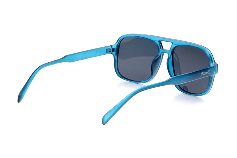 Gafas de Madera Natural de Pet MOUT. Las gafas de sol MOUT están fabricadas en plástico PET reciclado, transformando botellas en una montura ligera y resistente con marcado carácter deportivo. Su frontal rectangular de tamaño medio-grande, con doble puente integrado, aporta un aire retro inspirado en las gafas de aviador, mientras que el acabado translúcido en azul intenso les da frescura y un estilo muy actual. Las líneas definidas de la montura se equilibran con varillas finas y curvadas que se adaptan cómodamente a la cabeza, ofreciendo buen agarre sin presionar. Equipadas con lentes polarizadas de alta calidad, reducen reflejos y deslumbramientos y protegen totalmente frente a los rayos UV, convirtiendo a las MOUT en unas gafas recicladas ideales para quienes buscan comodidad, personalidad y compromiso con el planeta en una sola pieza. Dimensiones: 149x54mm; Calibre 57
 Venta al Por Mayor y Detalle | Root Sunglasses® 