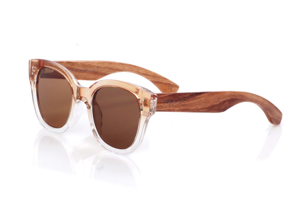 Gafas de Madera Natural de Zebrano modelo RIBSALA. Las gafas de sol <b>RIBASALA</b> combinan un frontal transparente en degradado champán con varillas de madera de zebrano, creando un contraste cálido y muy natural. Su forma suavemente cat-eye favorece rostros pequeños y medianos, aporta un toque luminoso y femenino y deja a la vista las vetas únicas de la madera, que hacen que cada par sea diferente. Ligeras y cómodas para uso diario, incorporan lentes polarizadas que reducen reflejos y protegen eficazmente frente a los rayos UV. Medidas: 142x52 mm. Calibre 50. | Root Sunglasses® 
