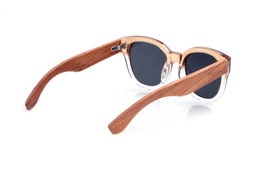 Wood eyewear of Zebrano RIBSALA. The RIBASALA sunglasses combine a transparent champagne gradient front with zebrawood temples, creating a warm and natural contrast. Their soft cat-eye shape flatters small to medium faces, adding a touch of luminosity and femininity while showcasing the unique wood grain, making each pair one of a kind. Lightweight and comfortable for everyday wear, they feature polarized lenses that reduce glare and provide effective UV protection. Measurements: 142 x 52 mm. Lens width: 50. for Wholesale & Retail | Root Sunglasses® 