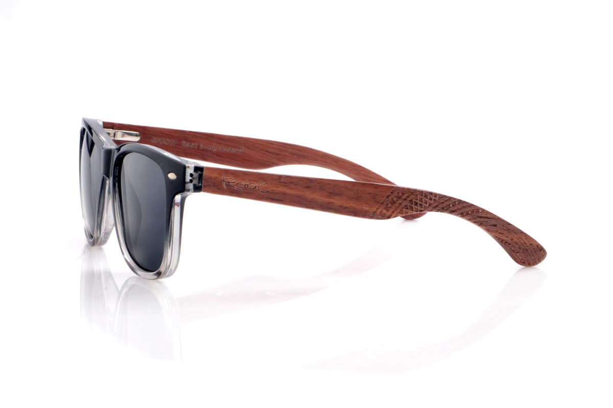 Gafas de Madera Natural de Walnut ISHCO. Las gafas de sol <b>ISHCO</b> combinan un frontal negro que se degrada suavemente a transparente en la parte inferior con unas varillas de madera de nogal, donde las vetas naturales y el grabado étnico en los extremos aportan un carácter muy especial. Los pequeños remaches metálicos del frontal refuerzan su aire clásico tipo wayfarer, mientras que la montura envolvente y las lentes polarizadas  garantizan una protección eficaz frente a los rayos UV sin renunciar a la comodidad en el día a día. Medidas: 145x50 mm. Calibre 51.
 Venta al Por Mayor y Detalle | Root Sunglasses® 