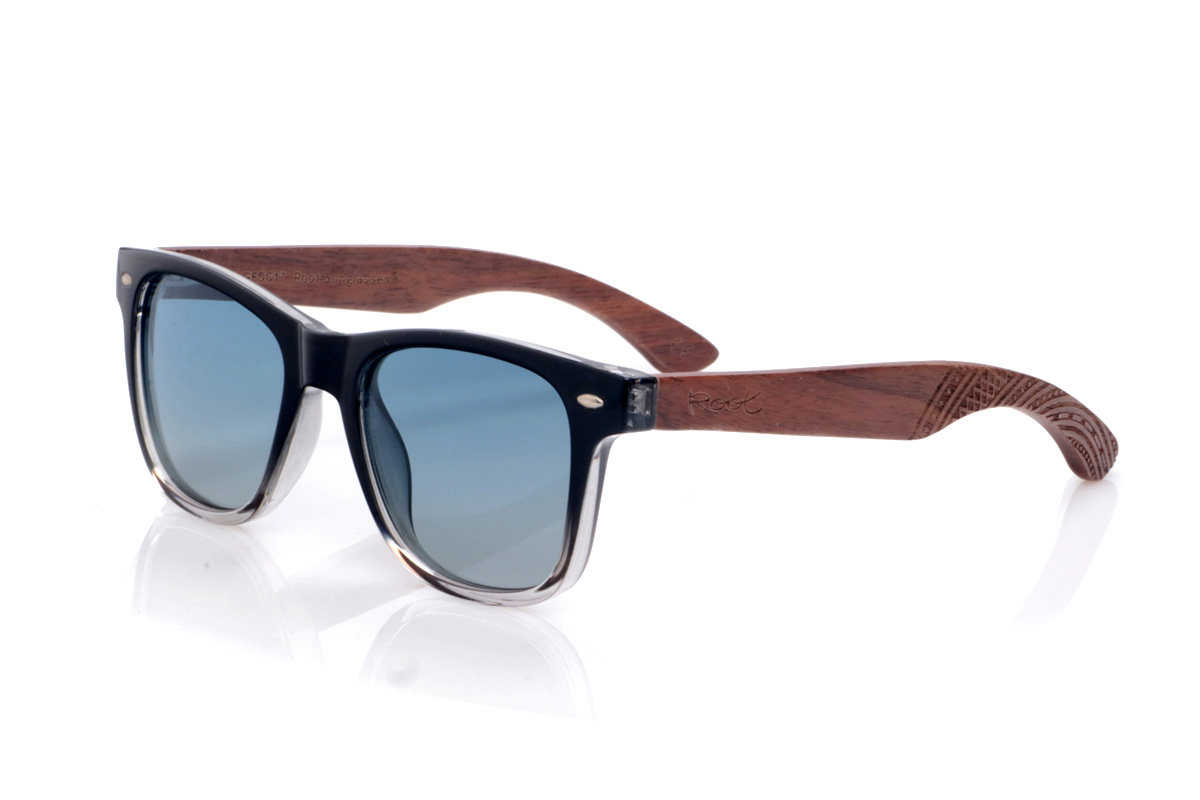Gafas de Madera Natural de Walnut modelo ISHCO. Las gafas de sol <b>ISHCO</b> combinan un frontal negro que se degrada suavemente a transparente en la parte inferior con unas varillas de madera de nogal, donde las vetas naturales y el grabado étnico en los extremos aportan un carácter muy especial. Los pequeños remaches metálicos del frontal refuerzan su aire clásico tipo wayfarer, mientras que la montura envolvente y las lentes polarizadas  garantizan una protección eficaz frente a los rayos UV sin renunciar a la comodidad en el día a día. Medidas: 145x50 mm. Calibre 51.
 | Root Sunglasses® 