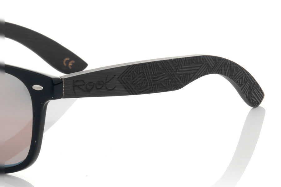 Wood eyewear of Bambú SKA BLACK. The Ska black sunglasses are made with the black glossy PC front and the black tinted natural bamboo wood sideburns engraved with an ethnic pattern, combined with various colors of lenses that suit your style. Frontal measurement: 148x50mm for Wholesale & Retail | Root Sunglasses® 