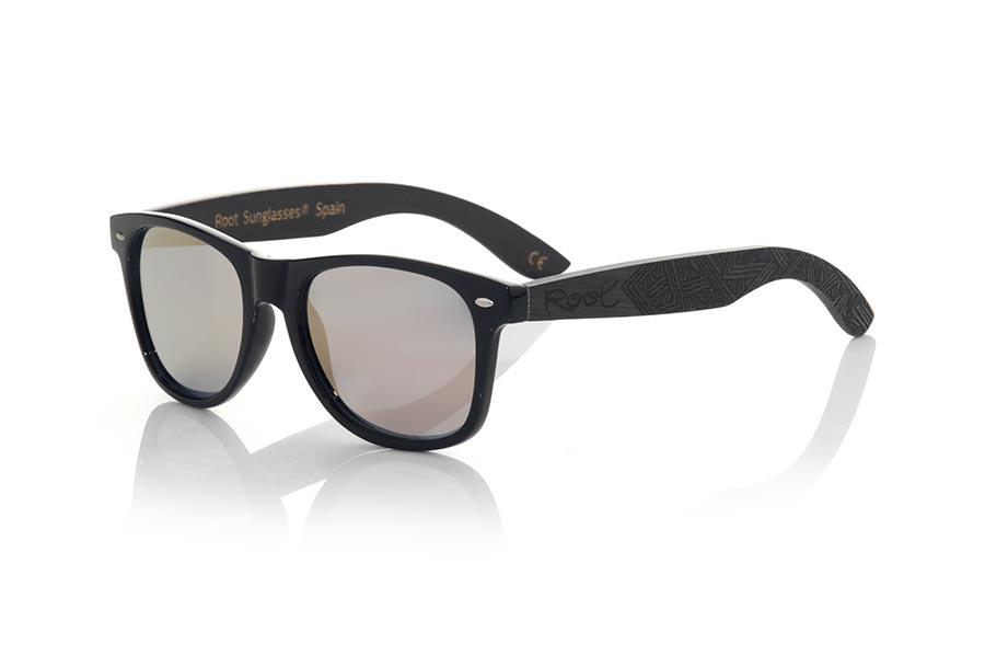 Wood eyewear of Bamboo modelo SKA BLACK. The Ska black sunglasses are made with the black glossy PC front and the black tinted natural bamboo wood sideburns engraved with an ethnic pattern, combined with various colors of lenses that suit your style. Frontal measurement: 148x50mm | Root Sunglasses® 