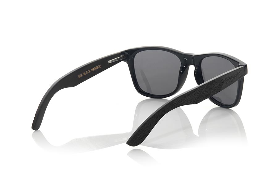 Gafas de Madera Natural de Bambú SKA BLACK. Las gafas de sol Ska Black están fabricadas con el frontal en PC negro brillo y las varillas de madera de bambú natural tintado negro grabadas con un patrón étnico, combinadas con varios colores de lentes que se adaptan a tu estilo. Medida frontal: 148x50mm Venta al Por Mayor y Detalle | Root Sunglasses® 